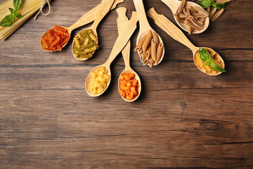 Different dry pasta on measuring spoons