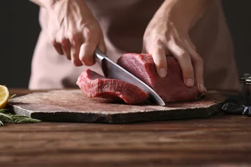 Schilderijen op glas Butcher cutting pork meat on kitchen © Africa Studio