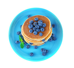 Tasty pancakes with blueberries on plate, isolated on white