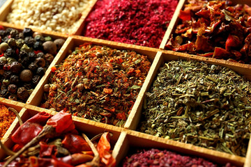 Different spices in wooden cells, closeup