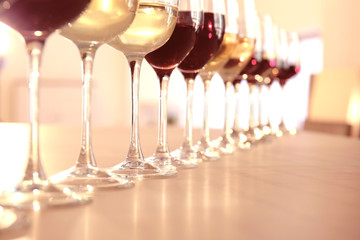 Glasses with red and white wine on table in restaurant