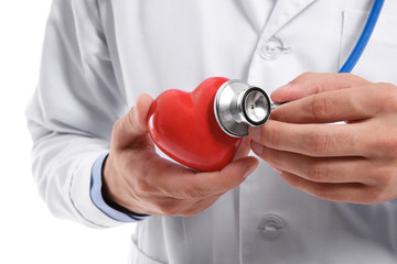 Male doctor holding red heart and stethoscope, closeup