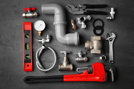 Plumber tools on a concrete structure background