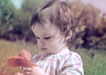 Beautiful baby girl with flower outdoor
