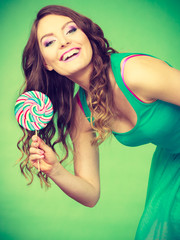 Smiling girl with lollipop candy on green