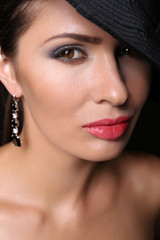 Portrait of young woman with beautiful makeup on black background, closeup