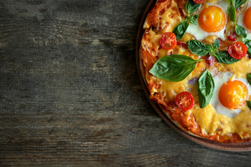 Margarita pizza with basil leaves and egg on wooden background