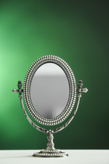 Female mirror on color background