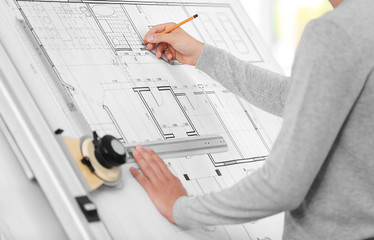 Young creative male engineer working with new project on drawing board