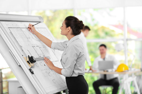 Young creative female engineer working with new project on drawing board