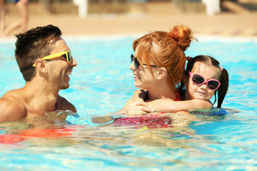 Happy family in swimming pool at water park