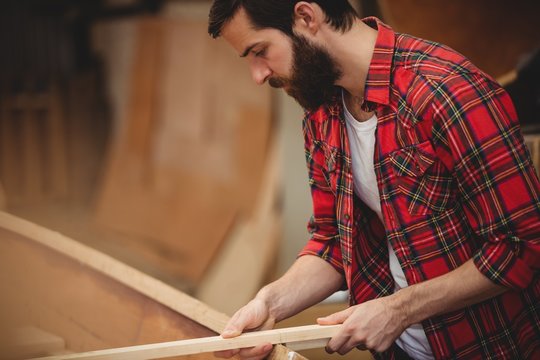 Man preparing wooden boat frame