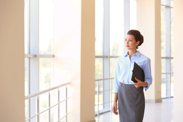 Beautiful businesswoman with clipboard in office