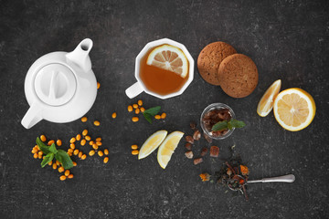 Obraz na płótnie Canvas Fresh tea ingredients and biscuits on grey background