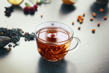 Cup of fresh tea with ingredients on table