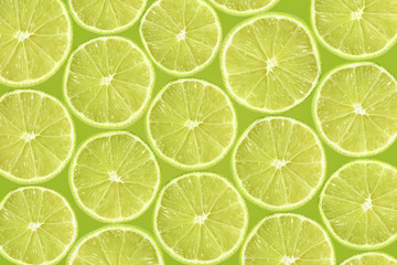 Fototapeta na wymiar Abstract green background with citrus-fruit of lime slices. Close-up pattern