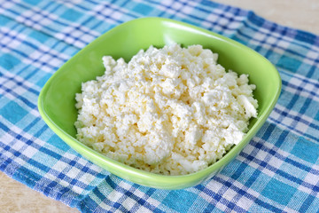 cottage cheese in green bowl on blue napkin