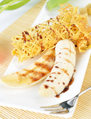 closeup image of a delicious pancakes with banana and chocolate syrup on it