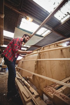 Man preparing wooden boat frame
