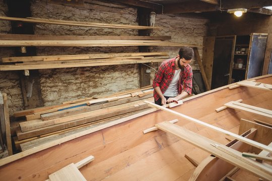 Man preparing wooden boat frame