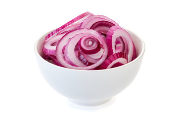 Sliced red onion in bowl on white.