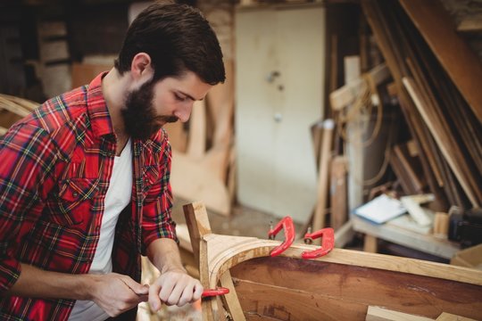 Man preparing wooden boat frame