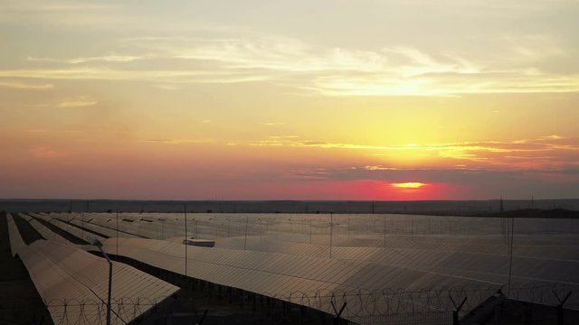 Time Lapse, Rich yellow, orange, red colors light up solar panel at sunset. 4k, solar panels in Russia in the Urals city of Orsk