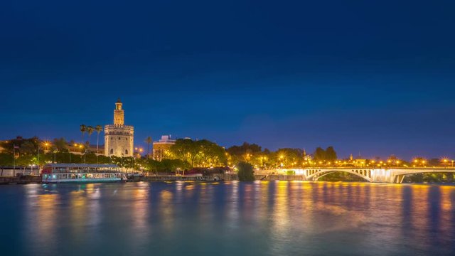 View of Golden Tower, Torre del Oro, of Seville, Andalusia, Spain over river Guadalquivir at sunset. Sunset timelapse with transition from day to night.