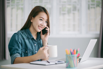 female talking on the phone and hand holding a cup