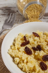 Cooked millet groats on white plate, healthy food and nutrition