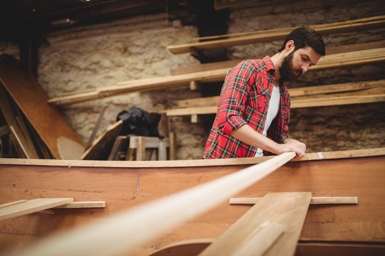 Man preparing a wooden boat frame