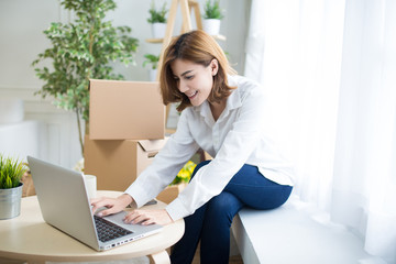 home, post, delivery and happiness concept - smiling young woman opening cardboard box at home