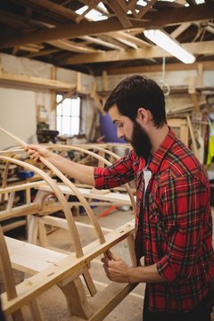 Man preparing a wooden boat frame