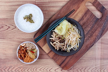 Rice gruel and fried mixed vegetable served side dish.  (topped roasted pumpkin kernel and  fried mushroom, bean sprouts,cabbage served side disk as bean cabbage,sweet radish and pickle ) 