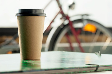 Disposable coffee cup on a table in artists studio interior.