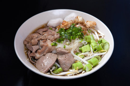 Rice noodle soup with Stewed pork with thai style on black wood