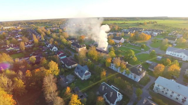 Intense fire in house. Blazing flame from windows and doors. Autumn / fall city landscape. Aerial footage.