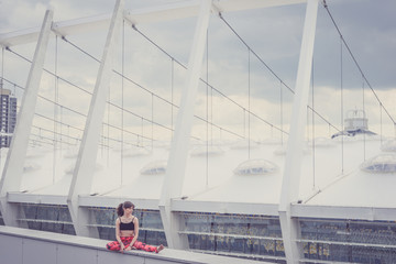 Woman doing yoga exercises outdoors in the city.Beautiful brunette fit young woman wearing sportswear practicing yoga urban style.Asana, working out,fitness,sport,training and lifestyle concept