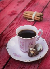 Vintage Decorative Coffee Mug on Red Wooden Background with Cinnamon Rolls
