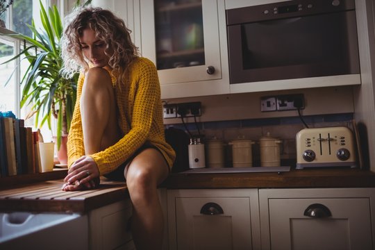 Beautiful woman sitting in kitchen