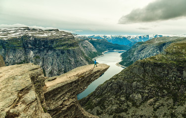 Woman On Trolltunga - View On Norway Mountain Landscape From Trolltunga - The Troll's tongue in Odda, Ringedalsvatnet Lake, Norway