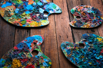 Painting palettes on wooden background