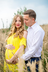 A young man hugs his pregnant wife