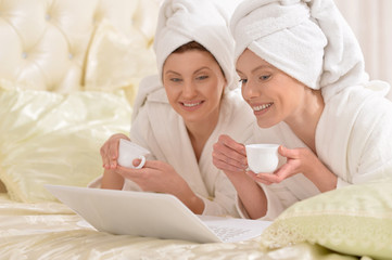 Obraz na płótnie Canvas women wearing a white bathrobes with tea