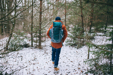 hiker walking on snow in the winter forest