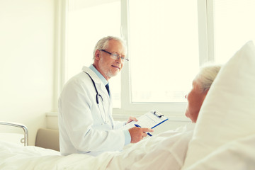 senior woman and doctor with clipboard at hospital