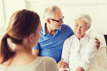 happy family visiting senior woman at hospital