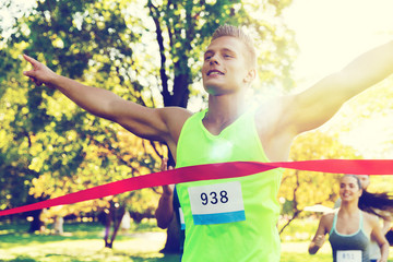 happy young male runner winning on race finish