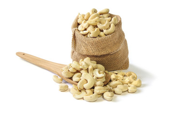 Cashew nuts in burlap sack on white background