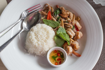 Fried basil leave with squid and shrimp on rice in white dish,Thailand food,Selective focus